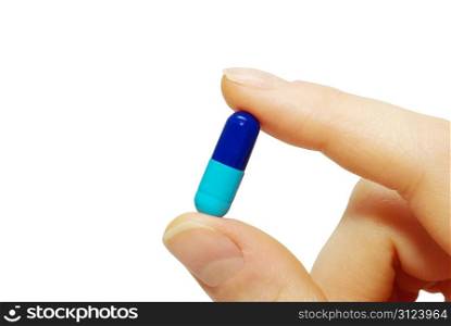 finger holds pill isolated on white