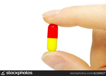 finger holds pill isolated on white