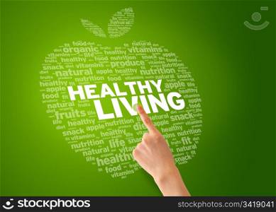 Finger pointing at an Healthy Living Apple on green background.