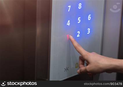 Finger pressing a number on the elevator.