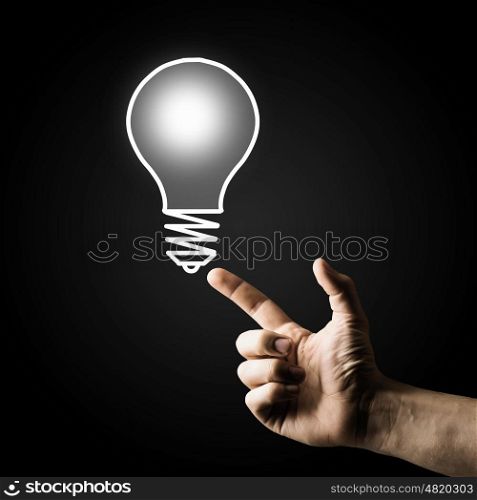 Finger touch light bulb. Human hand pointing with finger at light bulb