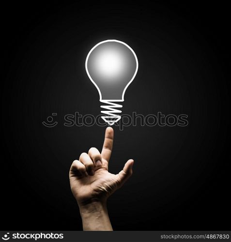 Finger touch light bulb. Human hand pointing with finger at light bulb