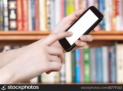 finger touches smart phone with cut out screen in library
