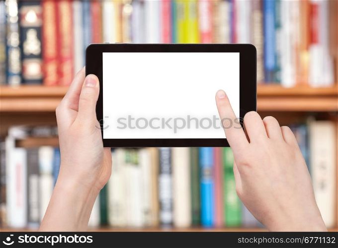 finger touches tablet pc screen with cut out screen on front of bookcase
