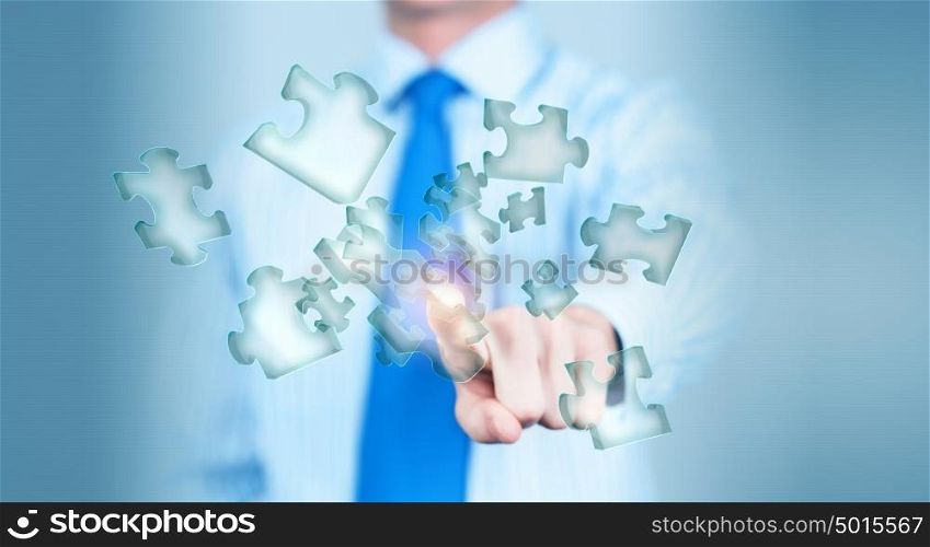 Finger touching icon. Close up of businessman&rsquo;s hand touching abstract puzzle piece