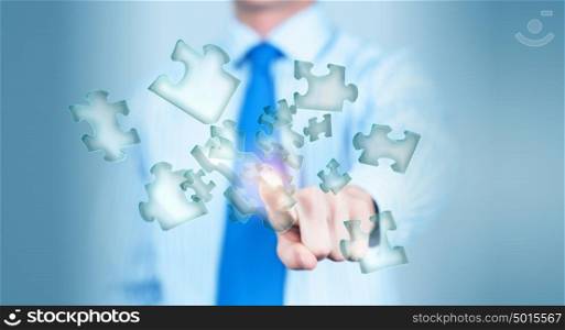 Finger touching icon. Close up of businessman&rsquo;s hand touching abstract puzzle piece