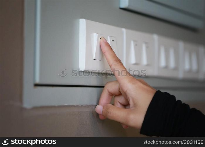 fingers are turning off light switch in the house.. fingers are turning off light switch in the house,concept for energy saving reduce global warming.