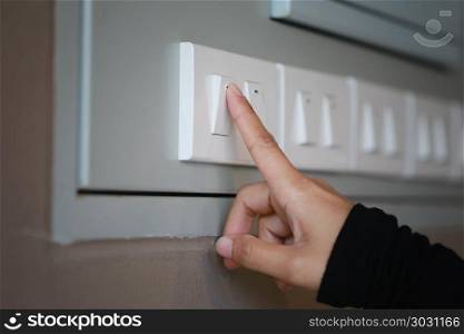 fingers are turning off light switch in the house.. fingers are turning off light switch in the house,concept for energy saving reduce global warming.