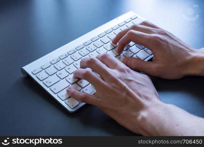 Fingers are typing on a white keyboard, online business