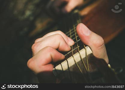 Fingers forming a chord on a guitar fingerboard. Male hand playing on guitar. Selective focus. Close up. Fingers forming a chord on a guitar fingerboard. Male hand playing on guitar. Selective focus