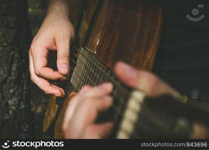 Fingers forming a chord on a guitar fingerboard. Male hands playing on guitar. Selective focus. Close up. Fingers forming a chord on a guitar fingerboard. Male hands playing on guitar. Selective focus