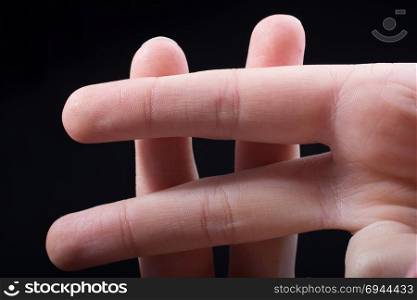 Fingers forming a hashtag symbol isolated on black background