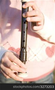 Fingers of Japanese girl playing the recorder
