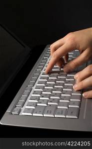 fingers over notebook keyboard