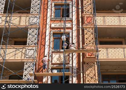 Finishing works on the facade of a new residential buildings. Building under construction