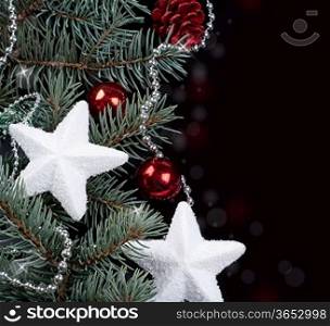 fir branch and Christmas decorations on a black background
