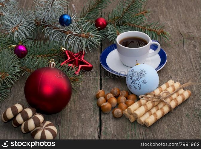 fir-tree branch with Christmas tree decorations, coffee, different baking and nutlets, a subject holidays Christmas and New Year