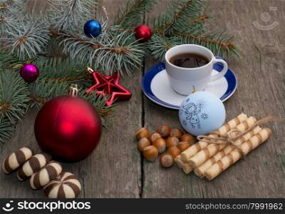fir-tree branch with Christmas tree decorations, coffee, different baking and nutlets, a subject holidays Christmas and New Year