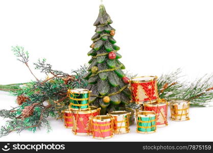 Fir tree candle and toy drums on white background.