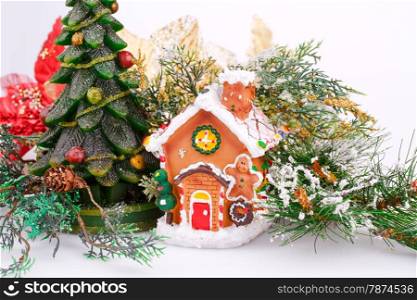Fir tree candle and toy house on gray background.
