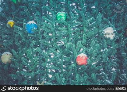 Fir tree decorated with colorful balls for Christmas time, filtered.