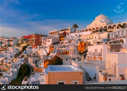 Fira, main town of the island Santorini, sea, white houses and church at sunset, Greece