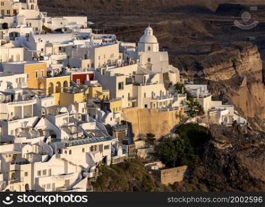 Fira, Santorini, Greece - June 27, 2021: The whitewashed town of Fira in warm rays of sunset on Santorini island, Cyclades, Greece. The whitewashed town of Fira in warm rays of sunset on Santorini island