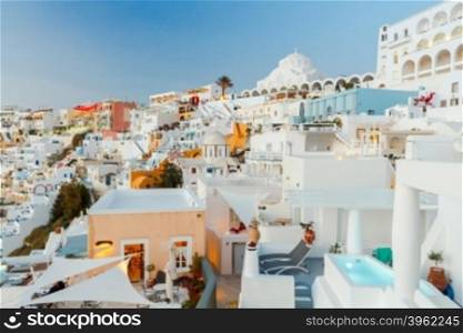 Fira, the capital of Santorini island. The white houses, terraces and Orthodox Cathedral on the steep slope of rocks at sunset.