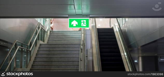 Fire Emergency exit sign on the wall inside building at subway train station. Safety concept