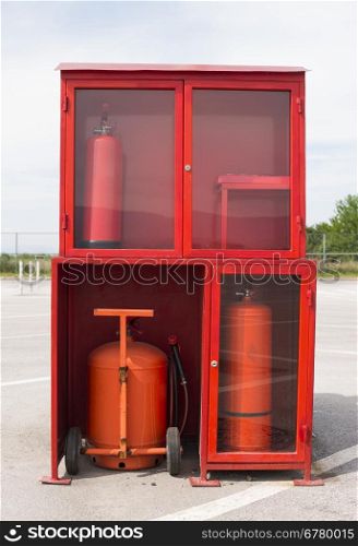 Fire extinguishers and fire fighting equipment. In the yard of an industrial building