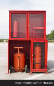Fire extinguishers and fire fighting equipment. In the yard of an industrial building