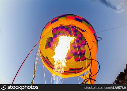 Fire heats the air inside a hot air balloon at balloon festival
