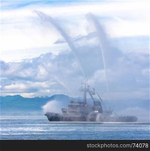 fire hose boat spraying water on Kamchatka on Paciic ocean