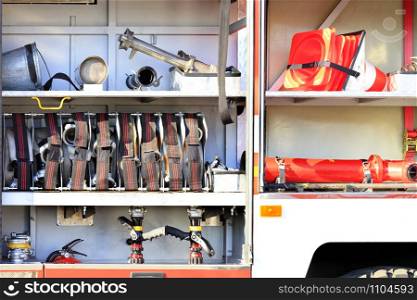 Fire hoses, valves, cranes, road cones, hydrants and a galvanized metal bucket are located in the cargo compartment of an equipped fire truck.. Fire hoses, valves and cranes, traffic cones are located in the cargo compartment of an equipped fire truck.