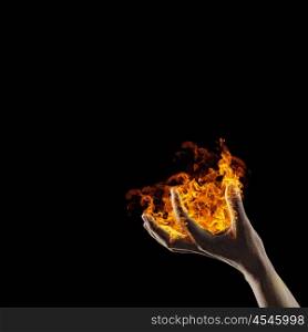 Fire in hand. Close up of human hand holding fire flame