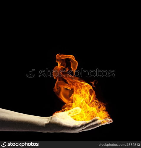 Fire in hand. Close up of human hand holding fire flame