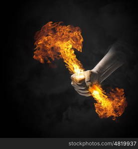 Fire in hand. Close up of human hand holding fire flame