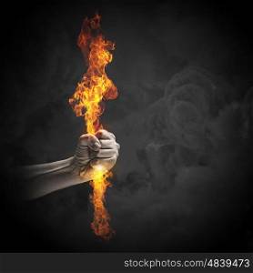 Fire in hand. Close up of human hand holding fire flame
