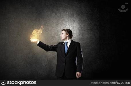Fire in hands. Young businessman holding fire flames in palm