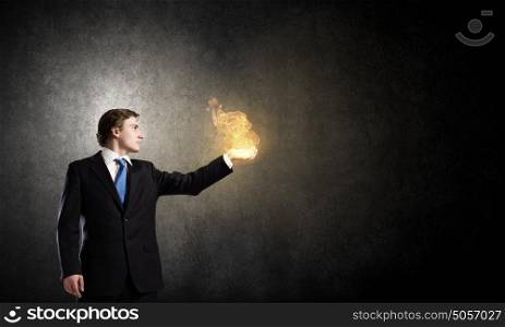 Fire in hands. Young businessman holding fire flames in palm