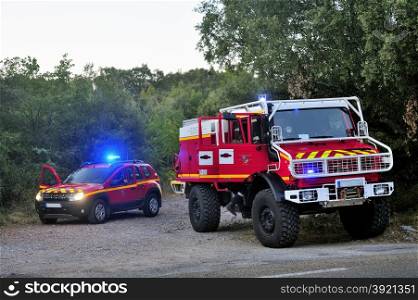 Fire trucks at the entrance of a forest road ready to go to the fire after the passage of trackers.