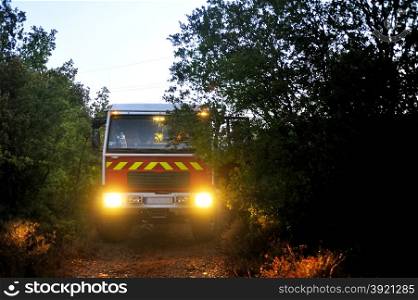 Fire trucks in a forest road the night after a forest fire in the French department of Gard.