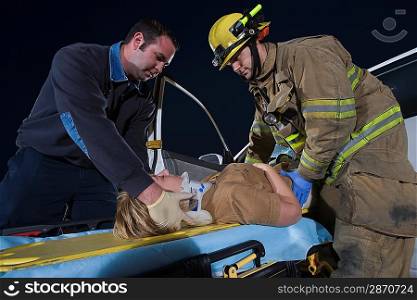 Firefighter and paramedic rescuing car accident victim