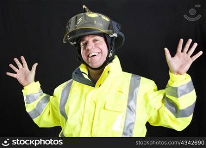 Firefighter lets off steam by goofing around. Photographed on black background.
