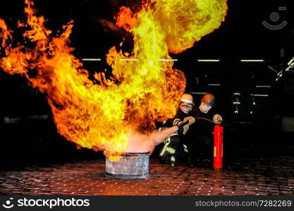 Firefighters training for fire fighting in Germany. Firefighter in fire protection suit spraying water to fire with smoke. Firefighter fighting fire attack, during training exercise