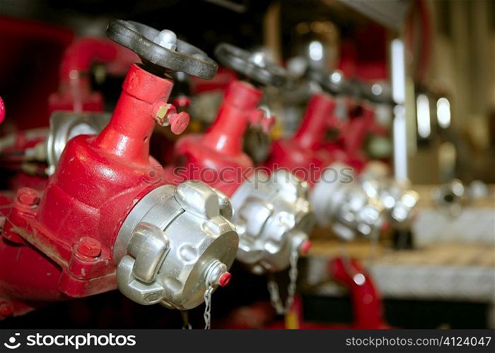 Fireman fire truck hose faucets in a row red and silver