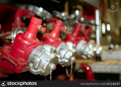 Fireman fire truck hose faucets in a row red and silver