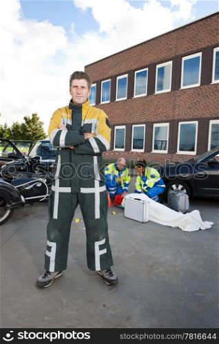 Fireman posing in his flame resistant coveralls in front of an accident site