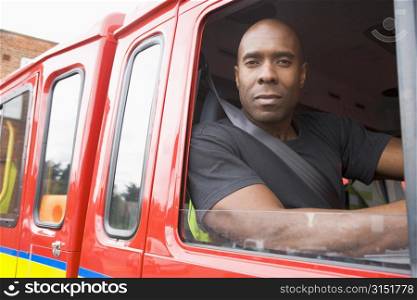 Fireman sitting in fire engine looking out window