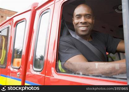 Fireman sitting in fire engine looking out window